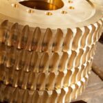 A stack of bronze gears on industrial table