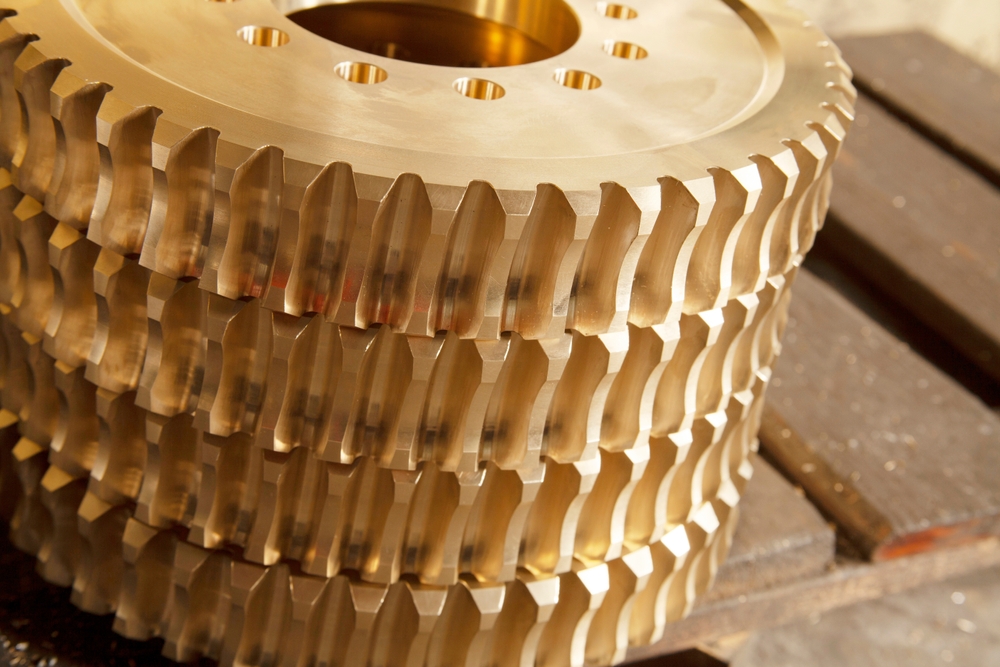 A stack of bronze gears on industrial table