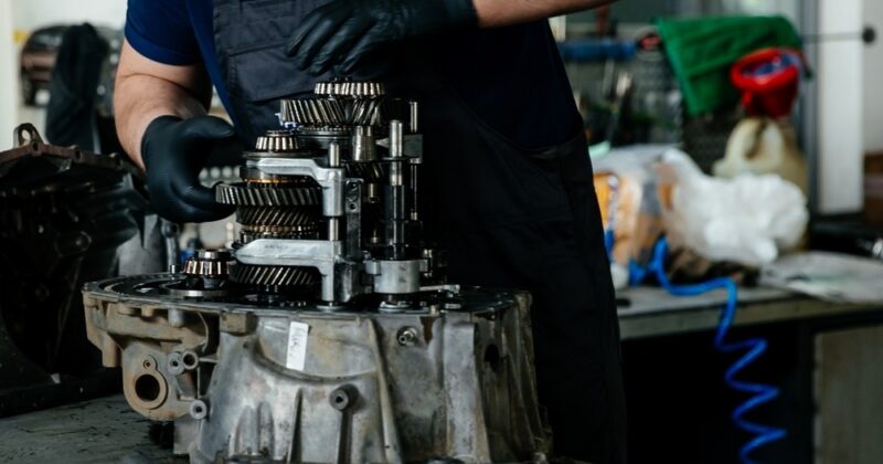 Technician repairing a disassembled gearbox.