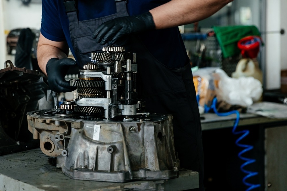 Technician repairing a disassembled gearbox.