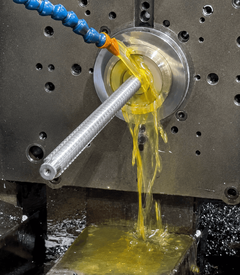 Example of broaching machine in action, metal broach tool with yellow lubricant.